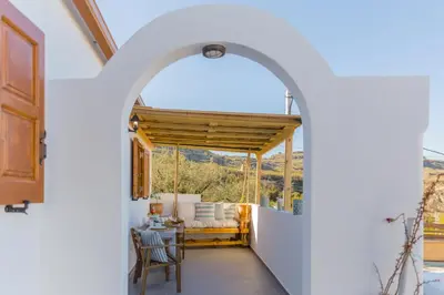 an archway leading into a room with a table and chairs at Lindos SeaView Apartment in Líndos