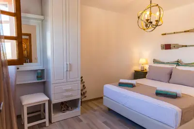 a bedroom with a bed and a mirror and a chandelier at Lindos SeaView Apartment in Líndos