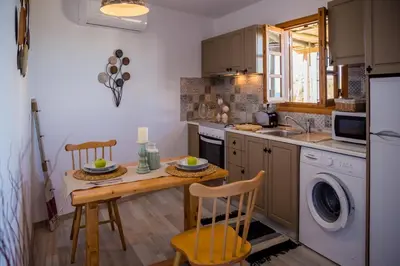 a kitchen with a table and a sink and a dishwasher at Lindos SeaView Apartment in Líndos