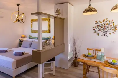 a bedroom with a bed and a dining table at Lindos SeaStar Apartment in Líndos