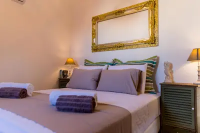 a bedroom with a large bed with a mirror on the wall at Lindos SeaStar Apartment in Líndos