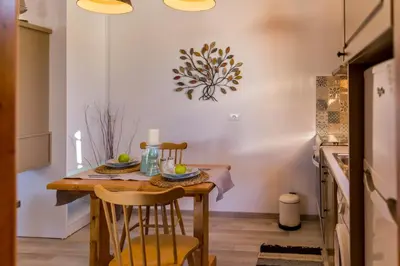 a kitchen with a wooden table and chairs at Lindos SeaStar Apartment in Líndos