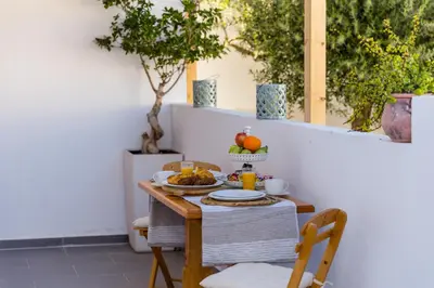 a table with a plate of food on it at Lindos SeaStar Apartment in Líndos
