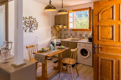 a kitchen with a table and a sink and a washing machine at Lindos SeaStar Apartment in Líndos