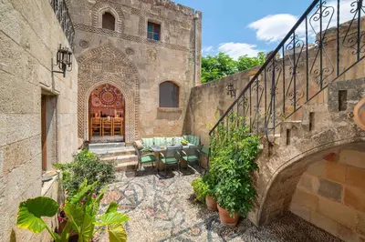 a patio with a table and chairs in front of a building at Captains House in Líndos