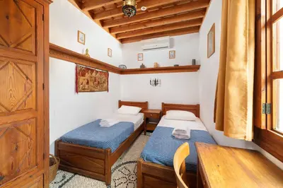 a room with two beds and a wooden door at Captains House in Líndos