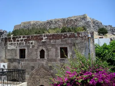 an old building with purple flowers in front of it at Captains House in Líndos
