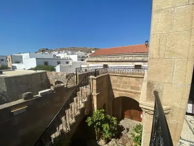 a stone building with a staircase and a bridge at Captains House in Líndos