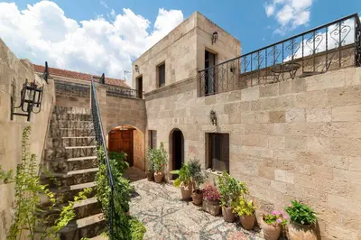 a stone building with potted plants and a staircase at Captains House in Líndos