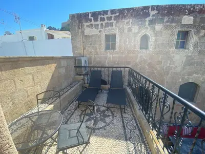 a balcony with tables and chairs on a building at Captains House in Líndos