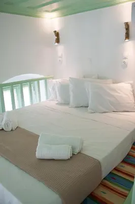 a large white bed with two towels on it at Villa Klytia in Halki
