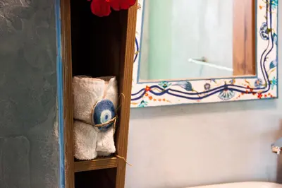 a shelf with towels and a mirror in a bathroom at Villa Klytia in Halki