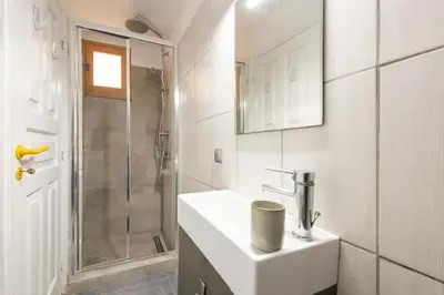 a white bathroom with a sink and a shower at Maison Roxanne & Maisonette in medieval city by Rhodes4vacation in Rhodes Town