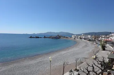 a view of a beach with the ocean and buildings at Horizon View Studio in Haraki