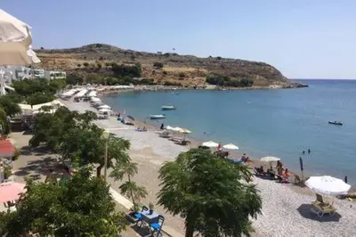 a beach with a bunch of umbrellas and a body of water at Horizon View Studio in Haraki