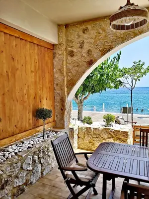 a patio with a table and chairs and the ocean at Relax Seaside House by living in blue in Haraki