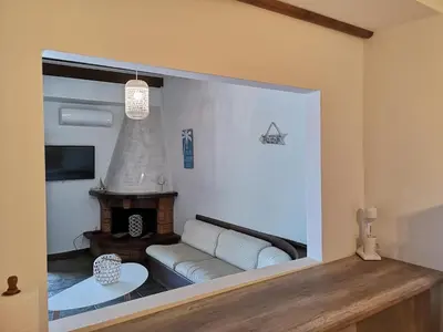 a living room with a couch and a fireplace at Relax Seaside House by living in blue in Haraki