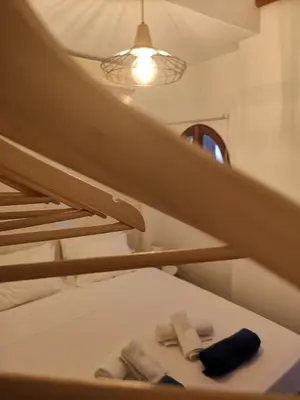 two slippers on a bed under a stairs at Relax Seaside House by living in blue in Haraki