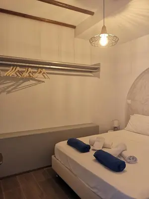 a bedroom with a bed with two towels on it at Relax Seaside House by living in blue in Haraki