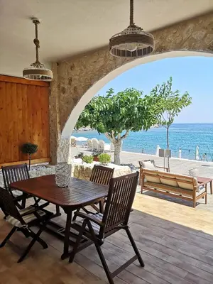 a dining room with a table and chairs and the ocean at Relax Seaside House by living in blue in Haraki