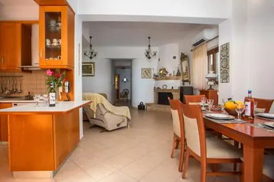 a kitchen and living room with a table and chairs at Christine Villa Pefkos in Pefki Rhodes