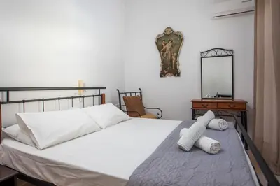 a bedroom with a white bed and a mirror at Christine Villa Pefkos in Pefki Rhodes