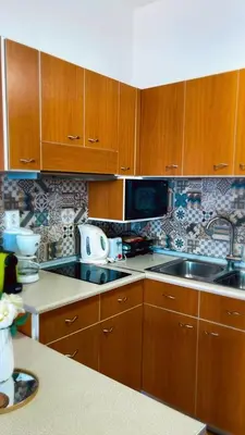 a kitchen with wooden cabinets and a sink at Haraki Dream View in Haraki