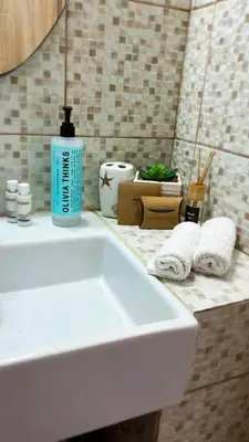 a bathroom sink with a blue bottle of soap and towels at Haraki Dream View in Haraki