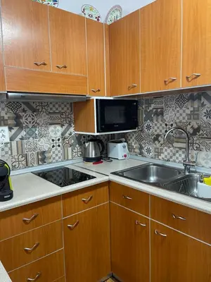 a kitchen with wooden cabinets and a sink and a microwave at Haraki Dream View in Haraki