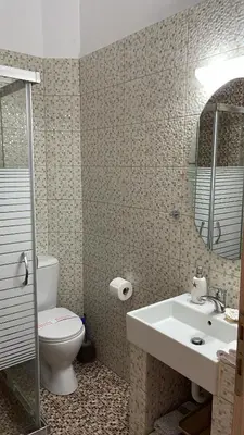 a bathroom with a sink and a toilet and a mirror at Haraki Dream View in Haraki