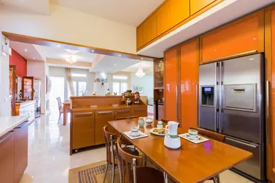 a kitchen with a wooden table and a stainless steel refrigerator at Kallithea Breeze Luxury Villa in Koskinou