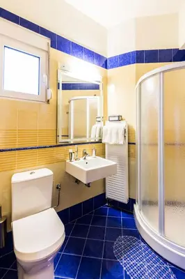 a bathroom with a toilet and a sink and a shower at Kallithea Breeze Luxury Villa in Koskinou