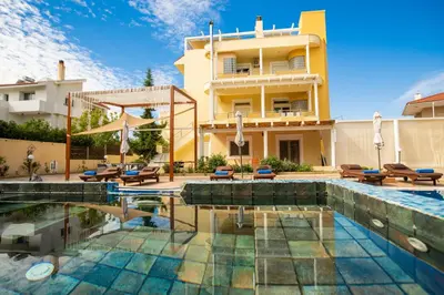 a house with a swimming pool in front of a building at Kallithea Breeze Luxury Villa in Koskinou