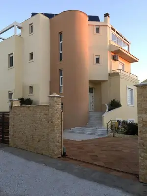 a large house with a stone wall in front of it at Kallithea Breeze Luxury Villa in Koskinou