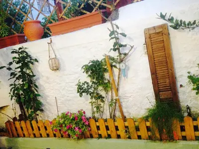 a white wall with a wooden fence and flowers at Praxitelous 9 Old Town in Rhodes Town