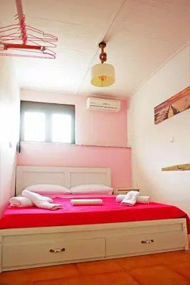 a bedroom with a large bed with red sheets at Praxitelous 9 Old Town in Rhodes Town