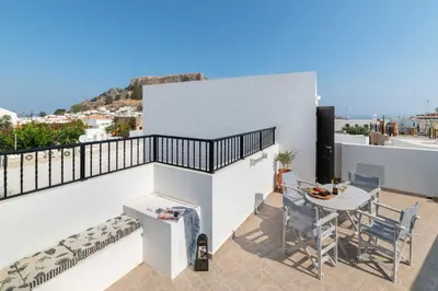 a view from the balcony of a house with a table and chairs at Lindos Olive Suites in Líndos