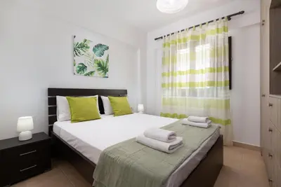 a bedroom with two beds with green pillows at Lindos Olive Suites in Líndos
