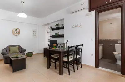 a living room with a table and chairs and a couch at Lindos Olive Suites in Líndos