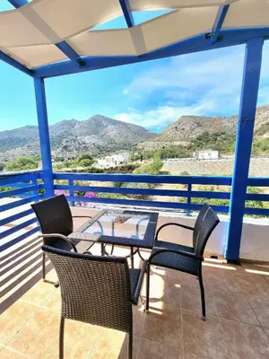 a balcony with chairs and a table with a view at Zafeiris Apartments in Livadia