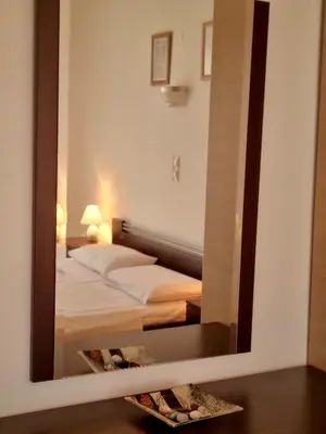 a mirror reflection of a bed in a bedroom at Zafeiris Apartments in Livadia