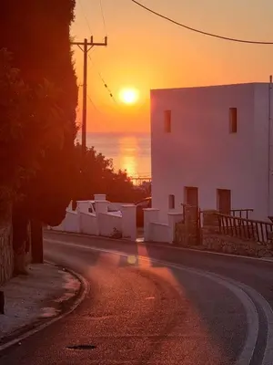 an empty street with a sunset in the background at Zafeiris Apartments in Livadia