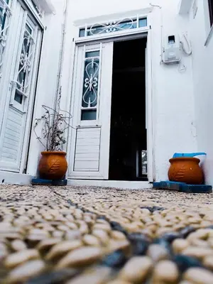 an open door with two pots in front of a building at Stam Luxury Traditional House in Koskinou