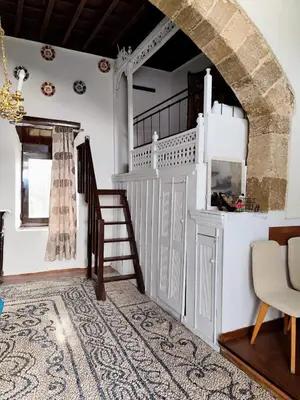 a living room with a staircase and a stair case at Stam Luxury Traditional House in Koskinou
