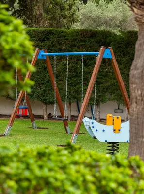 two swings in a yard with a tree at Bella Foresta Villa in Ialyssos