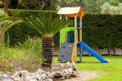 a playground with a slide in a yard at Bella Foresta Villa in Ialyssos