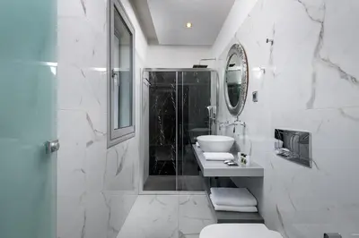 a white bathroom with a sink and a mirror at Bella Foresta Villa in Ialyssos