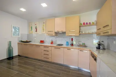 a kitchen with wooden cabinets and a counter top at Bella Foresta Villa in Ialyssos