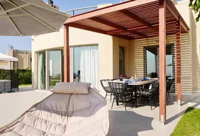 a patio with a table and chairs and an umbrella at Luxury Villa Trapezia in Afantou
