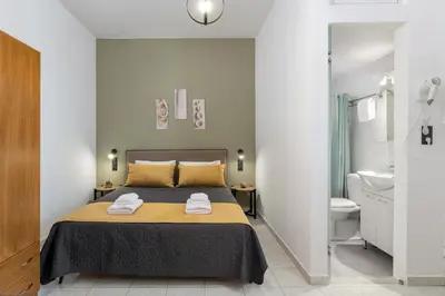 a bedroom with a bed and a bathroom with a toilet at Flora Studios in Líndos